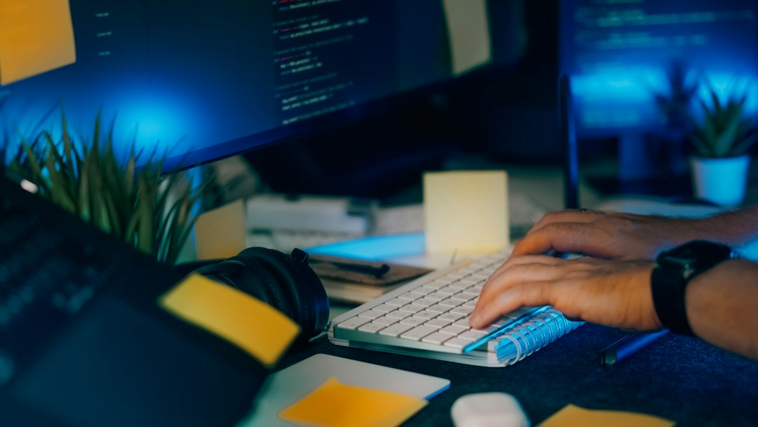 Pengembang bekerja dengan kode sumber di monitor komputer